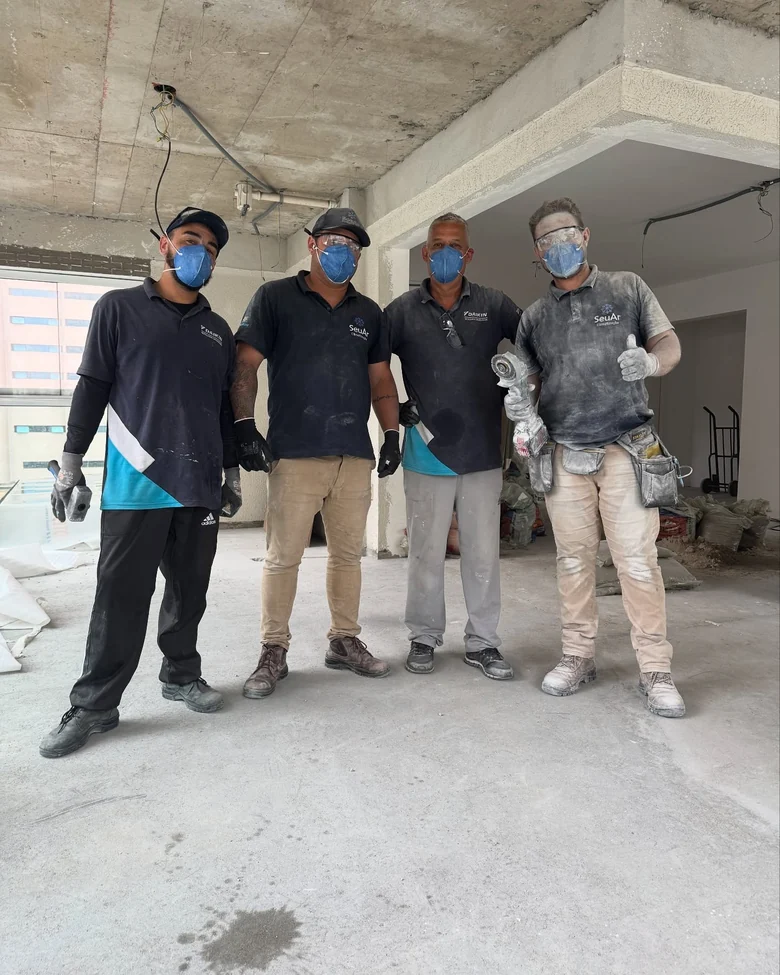 Equipe da SeuAr Climatização com EPI em uma obra de laje aparente, ainda sem forro
